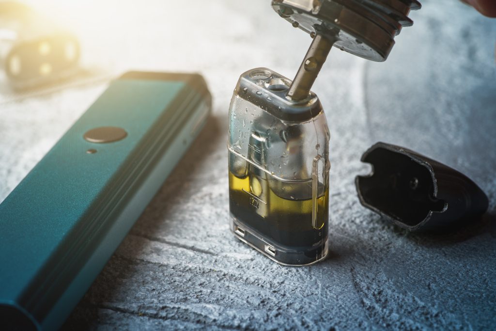 Vape liquid flavor is seen to be inserted into the pod.