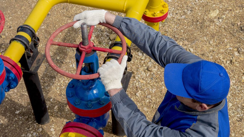 Worker is attempting to turn the valve