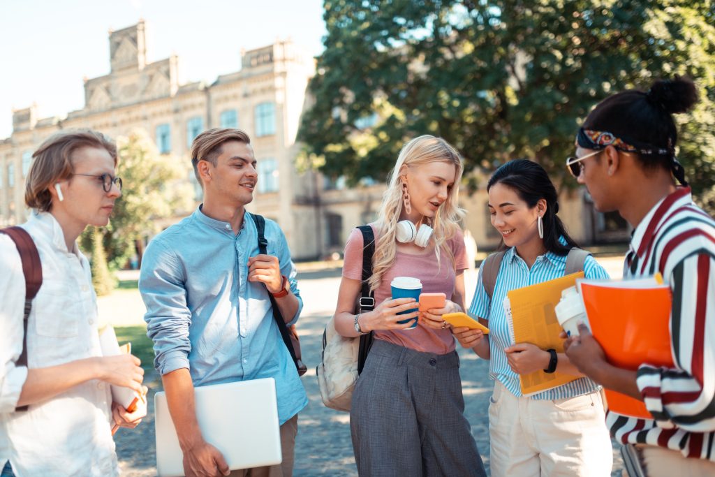 Cheerful students discussing outside campus
