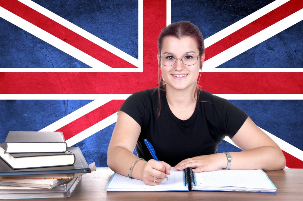A young girl student pc in the background with the British national flag.