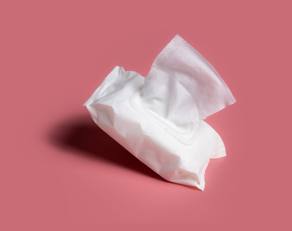 Open wet wipes flow pack on pink background