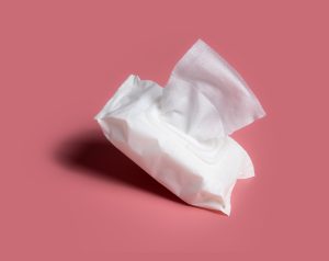 Open wet wipes flow pack on pink background
